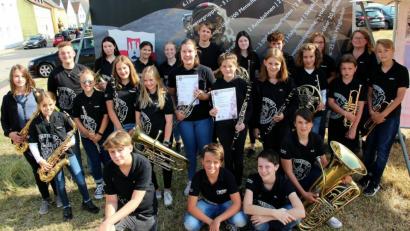 Bild: bph
Freudestrahlend präsentieren die ausgezeichneten Jungbläserinnen ihre Urkunden im Kreis ihrer Orchesterkollegen zusammen mit der Dirigentin des Nachwuchsorchesters, Karin Raab (Zweite von rechts).