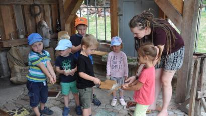 Bild: ak
Magdalena Wolf (rechts) zeigte den Mädchen und Buben, wie die Wolle ihrer Schafe verarbeitet wird.
