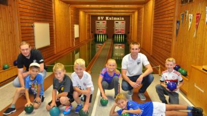 Bild: ak
Johannes Koch und Sebastian Fröhlich (hinten von links) leiteten die Kinder bei ihren ersten Kegelversuchen an.