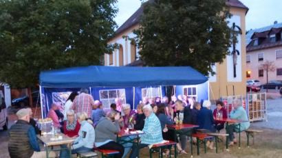 Bild: hme
Im Schatten der Bäume am Dorfplatz gemütlich beieinander sitzen, über allem wacht die Kirche St. Barbara
Bild aus 2018