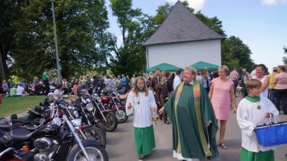 Bild: fvo
Pfarrer Albert Hölzl bei der Segnung der Motorräder, dabei werden kleine Fisch-Schlüsselanhänger an die Biker verteilt