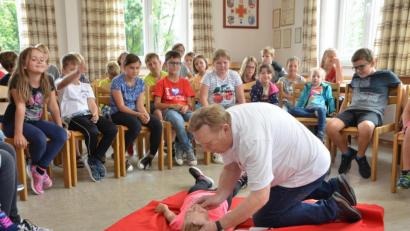 Bild: dob
Der Helfer vor Ort Josef Solfrank erklärt den Kindern genau, wie mit bewusstlosen Personen verfahren wird.