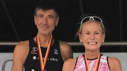 Bild: A. Schwarzmeier
Die deutschen Triathlon-Meister der AK 60 auf dem Siegertreppchen: Christiane Bardenheuer (Laface Team Weiden) und Frank Bachinger (EOSC Offenbach) strahlen um die Wette.