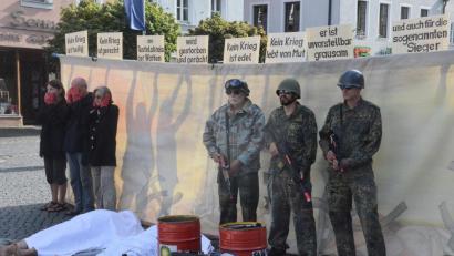 Bild: Kunz
Die Menschen bleiben stumm, sehen, hören weg. Derweil kämpfen Soldaten um die Ölvorkommen. Zurückbleiben Leichen. Im Hintergrund prangern Friedensaktivisten mit Textzeilen aus dem Pur-Song "Kein Krieg" den Rüstungswahnsinn an.