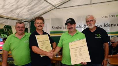 Bild: bey
Die Vorsitzenden der Siedlergemeinschaften Schwarzenfeld und Oberwildenau, Hans-Peter Hierl und Helmut Grünbauer, besiegeln die Patenschaft per Handschlag und Austausch der Patenschaftsurkunden. Zweiter Vorsitzender Artur Leonhardt (links) und Rudi Boritzka (rechts) freuen sich ebenfalls.
