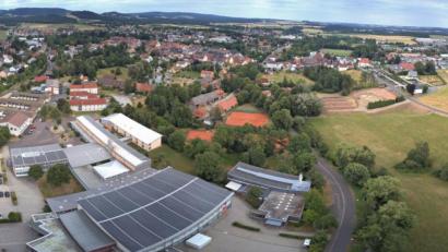 Bild: dtr
Statt sie zu sanieren, lässt der Landkreis Tirschenreuth die Kemnather Realschule (links) ein paar Meter weiter neu bauen. Dafür vorgesehen ist die Wiese zwischen Berndorfer und Badstraße (rechts). Im Vordergrund ist die Mehrzweckhalle zu sehen.