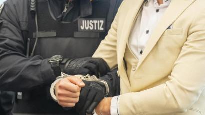 Bild: Matthias Rietschel
Der Angeklagte wird von einem Justizbeamten in den Gerichtssaal geführt.