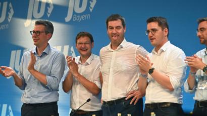 Bild: Nicolas Armer/dpa
Markus Söder (CSU, Mitte), Ministerpräsident von Bayern, steht nach seiner Rede mit durchgeschwitztem Hemd auf der Bühne und streckt aufgrund der warmen Temperaturen die Zunge heraus. Neben Söder stehen auf der Bühne stehen Markus Blume (von links), Generalsekretär der CSU , der scheidende JU-Landeschef Hans Reichhart, der als kommender JU-Landeschef nominierte Europaparlamentarier Christian Doleschal und Landtagsmitglied Stephan Ötzinger.