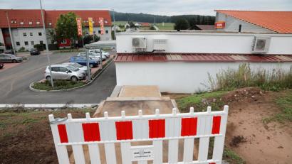 Bild: Wolfgang Steinbacher
Blick von der Schlossäckerstraße in Richtung SB-Markt: Die Absperrbake ist dringend erforderlich, denn der untere Treppenabsatz führt schnurstracks an die Kante einer geschätzt zwei Meter hohen Böschungsmauer.