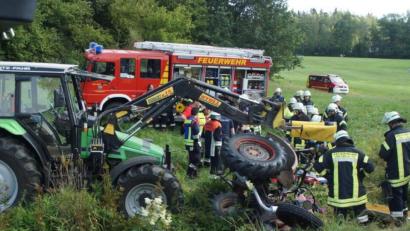 Bild: exb/Feuerwehr im Landkreis Schwandorf
In einem kleinen Bachlauf neben der Straße stürzte der Traktor älteren Baujahres um. Rettungskräfte mehrerer Feuerwehren kümmerten sich dann um die Bergung der beiden Verletzten. Behilflich war dabei auch ein Landwirt mit seinem Bulldog (links).