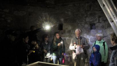 Bild: wec
Im Inneren des Bergfrieds. Eckart von Eyb (mit einem ausgedruckten Bild der Ansicht der mit einer Folie geschützten oberen Plattform des Turms), er zeigt den Besuchern viele interessante Details des 2003 restaurierten früheren Wohnturms.