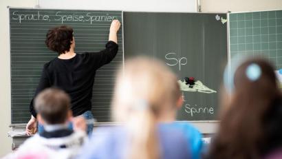 Bild: Sebastian Gollnow
Eine Lehrerin schreibt in einer Grundschule Wörter mit "Sp" am Anfang an eine Tafel. Foto: Sebastian Gollnow/Archivbild