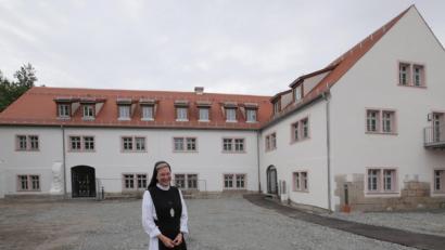 Bild: tr
Äbtissin Laetitia Fech vor dem generalsanierten Bestandsbau im ehemaligen Mühlenviertel.