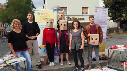 Bild: Bühner
Mit einer Papiertütenaktion und anderen Aktivitäten präsentieren sich drei lokale Beratungsstellen für psychische- und Suchtprobleme. Mit dabei anonyme Passanten unter Papiertüten und (von links) Diplomsozialpädagogin Ursula Breinbauer, Diplom-Psychologe Sebastian Babl, Sozialpädagogin Franziska Pausch und Psychologiestudent Benedikt Gailer.