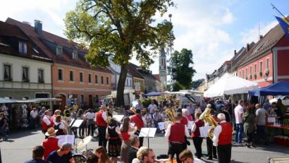 Bild: bey
Erstmals wurden über den Marktplatz verteilt kleine Sitzgruppen mit Biertischgarnituren aufgestellt, um die Besucher zum Verweilen auf dem Markt einzuladen, wie hier beim mittäglichen Standkonzert der Stadtkapelle Pleystein.
