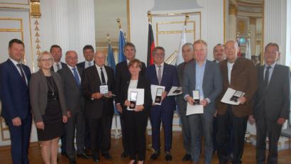 Josef Neubauer (mit Medaille, von links), Marianne Rauh, Reiner Gäbl, Johann Zehent, Roland Richter und Hans Kirschsieper nahmen die Auszeichnung in Regensburg von Regierungspräsident Axel Bartelt (Siebter von links) entgegen. Weitere Amtsträger gratulierten.