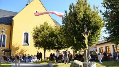 Bild: fjo
Kräftig bläst der "Böhmische" am Sonntagvormittag und die Gäste des Kirchenpatroziniums suchen füs Feiern Schutz im Windschatten von Pfarrkirche und Kolpingheim.