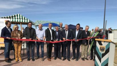 Bild: eig
Bürgermeister Günter Stich (Vierter von rechts) zückt die Schere und mit ihm durchschneiden Vertreter der an Ausweisung, Planung und Bau Beteiligten das symbolische rote Band: "Auf eine gute Zukunft!"