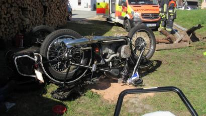 Bild: pp
Von der Straße in den Vorgarten: Das Motorradgespann landete kopfüber zwischen Holz und Gartengeräten.