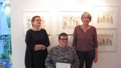 Bild: rbr
Die den Künstler betreuende Heilpädagogin Renate Höning, Wolfgang Bauer mit dem illustrierten Buch und die Kunstpädagogin Irene Fritz (von links) eröffnen die Ausstellung „Vom Glück, fliegen zu können“.