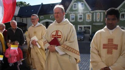Bild: wro
An den Kirchenstufen wurde der neue Pfarrer von den Gläubigen gestoppt, um ihn dann in die Kirche zu begleiten. Im Bild (von rechts) Pater und Pfarrvikar Charles John, Markus Nees und Dekan Thomas Vogl.