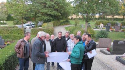 Bild: aks
Vor Ort erläutert Architekt Werner Hedrich (vorne links) Bürgermeister Hans-Jürgen Strehl (rechts) und den Gemeinderäten die Planungen für die neue Aussegnungshalle.