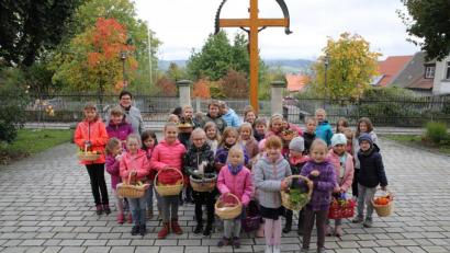 Bild: njn
Zusammen mit Gemeindereferentin Roswitha Heining (hinten links) brachten die Kinder ihre Erntedankgaben in Körbchen mit zum Familiengottesdienst.