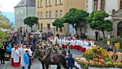 Bild: bph
Zahlreiche Gläubige jeden Alters, unter ihnen Vertreter der weltlichen und der kirchlichen Gremien sowie die Fahnenabordnungen der kirchlichen und vieler weltlicher Vereine, hatten sich auf dem Unteren Markt versammelt und erwarteten das Eintreffen des Pferdegespannes mit dem reichgeschmückten Erntewagen. Mit einem kurzen Standkonzert eröffnete die Jugendblaskapelle die Feier.