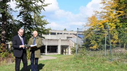 Bild: exb
Landrat Andreas Meier (links) und Kreisbaumeister Werner Kraus schmieden Pläne, die Dreifachturnhalle des Gymnasiums Neustadt abzureißen und auf dem Kugelstoßgelände der Schule (rechts) neu zu bauen.