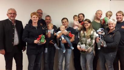 Bild: hos
Bürgermeister Rudolf Schopper (links) und Vertreter der Feuerwehr begrüßen sieben kleine Püchersreuther und übergeben ihren Eltern Rauchmelder für die Kinderzimmer und schenken den Kleinen Plüschdrachen.