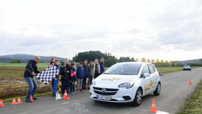 Bild: bey
André Helwig, ADAC Nordbayern, sitzt am Steuer, Matthias Kastner, ADA Weiden, schwenkt die Zielflagge: Nach der Vollbremsung zeigt sich, wie lange der Bremsweg beim 50 km/h ist. Die Schülerinnen und Schüler beobachten das Bremsmanöver fasziniert.
