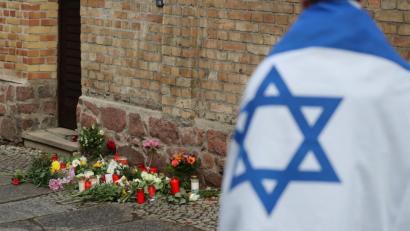 Bild: Jan Woitas/dpa
Ein Mann mit einer Israel-Flagge trauert vor der Synagoge von Halle. Viel zu viele Menschen trauern jedoch nicht wegen des Vorfalls, sondern heißen ihn gut. Auch in der Oberpfalz leben solche Menschen