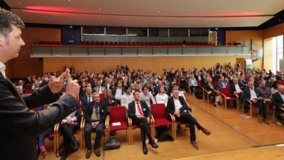 Bild: Wolfgang Steinbacher
Rüdiger Maas (links) bringt den 400 Teilnehmern der bayernweiten "SchuleWirtschaft"-Tagung nahe, wie die Generation Z tickt. Ehrenamtliche Vertreter aus rund 100 lokalen Arbeitskreisen kommen dabei zum Erfahrungsaustausch und zur Vernetzung im ACC zusammen.