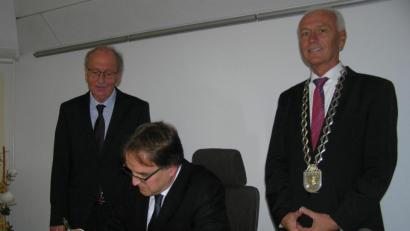 Bild: öt
Regierungsvizepräsident Christoph Reichert trug sich bei seinem Besuch in Neusorg im Beisein von Bürgermeister Peter König (rechts) und dessen Stellvertreter Dr. Günther Fütterer (links) ins goldene Buch der Gemeinde ein.