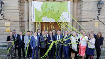 Bild: Daniel Löb/exb
Die Projektpartner vernetzen sich: In der vorderen Reihe (Mitte) Staatsminister Bernd Sibler mit den Landtagsabgeordneten Hans Herold und Holger Dremel (lnks) und Landrat Kalb sowie Waldsassen Bürgermeister Sommer (rechts ). Die Bänder werden von den Vertretern der jeweiligen Klosterlandschaften gehalten.