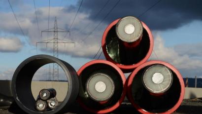 Bild: Julian Stratenschulte/dpa
Zwei Prototypen für Erdkabel mit drei Adern unter einer Hochspannungsleitung.