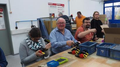 Bild: bl
Bürgermeister Heinz Weigl (Zweiter von links) montiert Seite an Seite mit den Beschäftigten der Naabwerkstätten in Oberviechtach Köpfe für Feuerlöscher. Beim "Schichtwechsel" erfährt er, was die Menschen mit Handicap leisten.