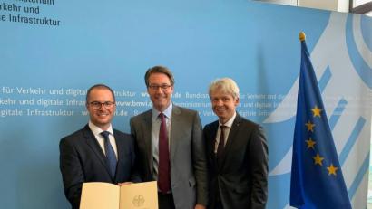 Bild: exb/BMVI
8,4 Millionen Euro im Din-A4-Format: Bundesminister Andreas Scheuer (Mitte) übergibt den Professoren Steffen Hamm (links) und Clemens Bulitta die Förderzusage in Berlin.