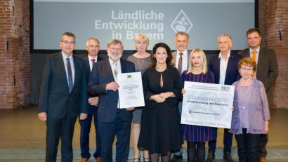 Bild: Seyfarth/StMELF/exb
Die Marktgemeinde Mähring hat in vorbildlicher Weise das ehemalige Schul- und Rathaus saniert. Dafür überreichte Ministerin Michaela Kaniber (vorne, Mitte) an Bürgermeister Josef Schmidkonz (Dritter von links) den Staatspreis für Dorferneuerung und Baukultur.