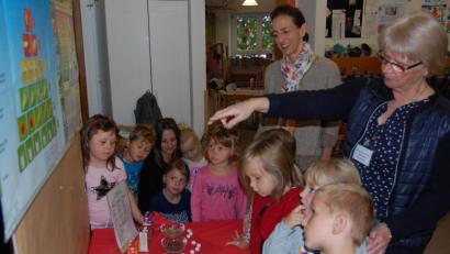 Bild: grm
Ökotrophologin Angelika Meindl erklärt den aufmerksamen Kleinen gesunde und weniger gesunde Lebensmittel, die anschaulich auf grünen und roten Deckchen verteilt sind. Mit im Bild Projektmanagerin Anna Lilliu (stehend Mitte).