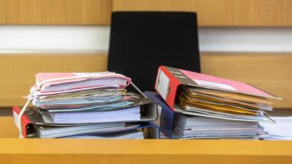 Archivbild: Armin Weigel/dpa
Akten liegen im Verhandlungssaal des Landgerichts in Deggendorf.