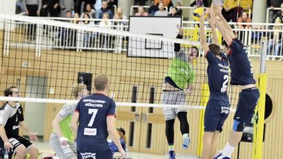 Bild: Hubert Ziegler
Der Münchener Zweierblock (rechts) kann den Netzangriff des Amberger Außenangreifer Neuzugangs Paul Seidel (rechts hinten) blocken, beobachtet von Mittelblocker Florian Wachler (Mitte hinten) und VCA-Libero Florian Birner (links hinten).

Bild: Ziegler