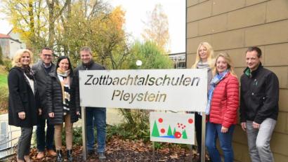 Bild: bey
Pleysteins Zweite Bürgermeisterin Andrea Lang und Schulleiter Edgar Hanner (von links) freuen sich über das neue Schild an der Zottbachtalschule, das Margit und Stefan Voit (Dritte und Vierter von links) designed und gefertigt haben. Lehrerin Martin Röder (Zweiter von rechts) hat die von Iris Merold (Dritte von rechts) entworfene Grafik umgesetzt.