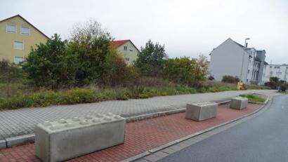 Bild: Dobmeier
Betonklötze auf dem Parkstreifen an der Lidl-Einfahrt verhindern das Parken von Autos, unbebaute Grundstücke verwildern.