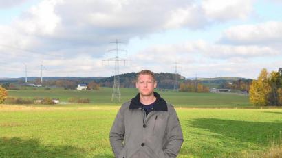 Bild: fjo
Manfred Striegl aus Lohma kümmert sich um das Projekt einer weiteren Sonnenstromanlage in unmittelbarer Nähe der 380-kv-Leitung (Mitte) aus Tschechien. Die beiden Waidhauser Windräder (links) und der Verlauf der A 6 (rechts hinten) dienen der bildlichen Orientierung.
