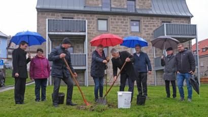 Bild: nm
Es hat viel zu tun gegeben, um die "Flosser Straße 6" wieder bewohnbar zu machen. Abschluss ist die Segnung des Hauses und eine Baumpflanzung. Der strömende Regen stört nicht.