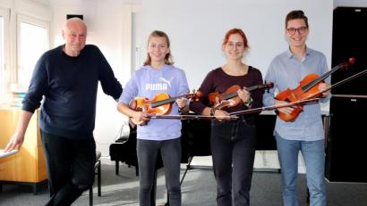 Bild: StR Mathias Dietz/exb
Vorbereitung auf das Internationale Jugendorchester (von links): Dirigent Graham Buckland sowie Antonia Keppler, Theresa Frauendorfer und Franz Schottenheim am Max-Reger-Gymnasium.