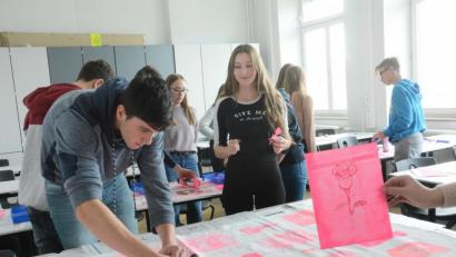 Bild: Gabi Schönberger
Rosa Rosen drucken die Schüler des Augustinus-Gymnasiums auf eine Stoffbahn, mit der sie sich an der Aktion "Rosen statt Veilchen" beteiligen und gegen Gewalt an Frauen einsetzen.