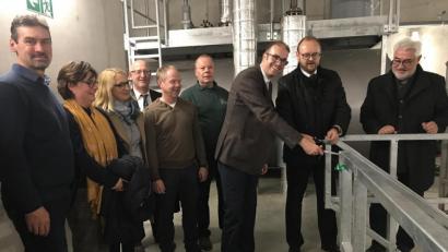 Bild: eig
Landrat Andreas Meier und der EDL-Geschäftsführer Dr. Carsten Schaefer (Zweiter und Dritter von rechts) durchschneiden das Band zur Treppe in die Tiefen des Heizwerks. Bürgermeister Rupert Troppmann (rechts), der Naturenergie-Geschäftsführer Hans-Peter Lang (Vierter von rechts) und die Schulleiter beobachten den offiziellen Akt. .