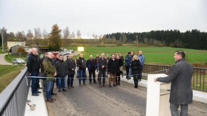 Bild: bey
Bürgermeister Rainer Rewitzer (rechts am Pult) freut sich bei der offiziellen Einweihung der Brücke über die Pfreimd, das die Kostenschätzung mit den tatsächlichen Kosten übereinstimmt.